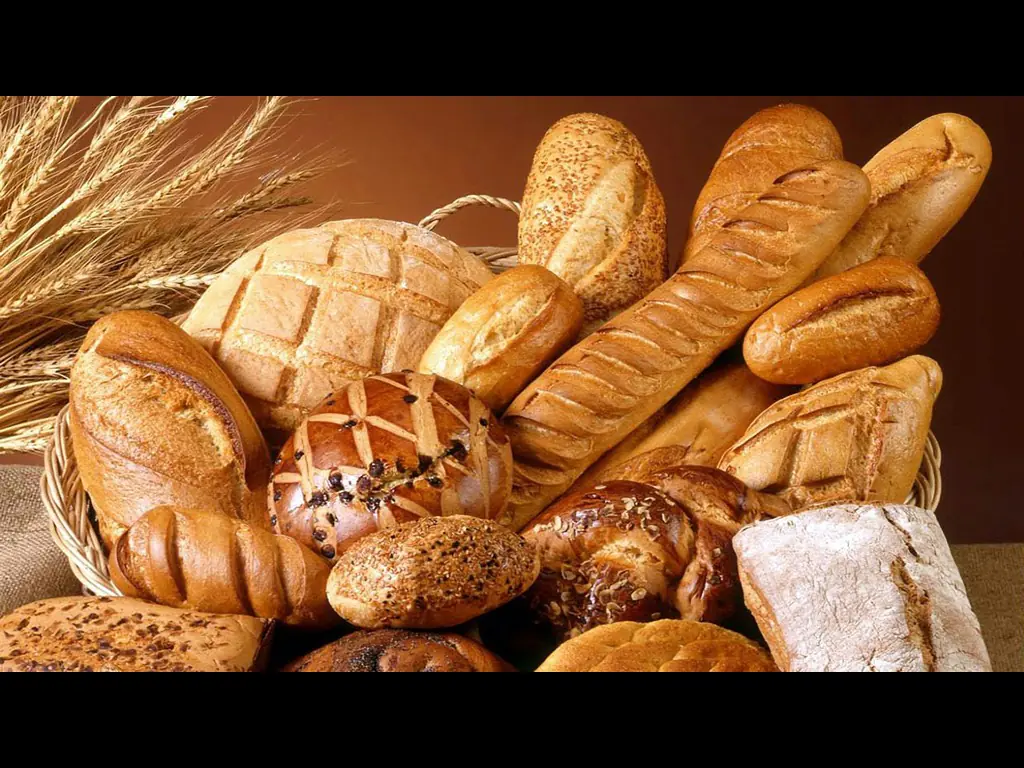 Un empilement de pains, de petits pains et de baguettes fraîchement cuits.
